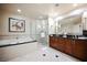 Bright bathroom features a soaking tub, walk-in shower with glass, double vanity, and elegant fixtures and mirrors at 135 E Harmon Ave # 407, Las Vegas, NV 89109
