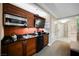 Practical kitchenette includes microwave, sink, and mini-fridge built into attractive wooden cabinets with black countertop at 135 E Harmon Ave # 407, Las Vegas, NV 89109