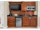Hotel kitchenette featuring wood cabinets, modern appliances, a sink, and a mini-refrigerator at 135 E Harmon Ave # 407, Las Vegas, NV 89109