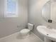 Powder room featuring a modern sink, toilet, and window with blinds at 3408 Isle Dr, Las Vegas, NV 89141