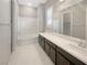 Bright bathroom features a soaking tub, tiled floors, and expansive vanity with large mirror at 3408 Isle Dr, Las Vegas, NV 89141
