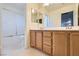 Bathroom with wood cabinets, double sinks, and a shower/tub combo at 6019 Orca Lilly St, North Las Vegas, NV 89031