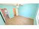 Bright bedroom featuring blue walls, neutral carpet, ceiling fan and walk in closet at 6019 Orca Lilly St, North Las Vegas, NV 89031