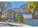 Two-story house with gray siding, white garage door, and landscaping at 6019 Orca Lilly St, North Las Vegas, NV 89031