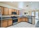 Kitchen with wood cabinets, granite countertops, and stainless steel appliances at 6019 Orca Lilly St, North Las Vegas, NV 89031