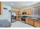 Bright kitchen featuring stainless steel appliances, wood cabinets, and white tile flooring at 6019 Orca Lilly St, North Las Vegas, NV 89031