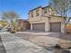 Two-story house with stone accents and a three-car garage at 1090 Via Pareda Pl, Henderson, NV 89011