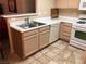 Kitchen featuring laminate counter, wooden cabinets, white appliances, and a double sink at 3046 Tarpon Dr # 103, Las Vegas, NV 89120