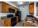 Efficient kitchen featuring black appliances, wood cabinets, and double stainless steel sink, with tile flooring at 3550 Bay Sands Dr # 2076, Laughlin, NV 89029