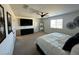 Carpeted primary bedroom featuring neutral walls, ceiling fan, and a large window with natural lighting at 6843 Toros St, North Las Vegas, NV 89086