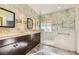 Elegant bathroom featuring double sinks, stone-style tile backsplash and a glass shower enclosure at 1363 Yeager Ave, Las Vegas, NV 89123