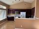 Eat-in kitchen boasts dark wood cabinets, stainless steel appliances, and a vaulted ceiling at 1531 Singing Bird Ln, North Las Vegas, NV 89031