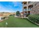 Backyard view showing a putting green, patio, and outdoor kitchen with golf course views at 2870 Quartz Canyon Dr, Henderson, NV 89052