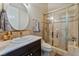 Bathroom with round mirror, granite countertop, and glass enclosed shower at 2870 Quartz Canyon Dr, Henderson, NV 89052
