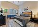 Comfortable bedroom with a bamboo headboard, hardwood floors, and blue bench under window at 2870 Quartz Canyon Dr, Henderson, NV 89052