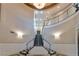 Elegant two-story foyer with grand staircase, chandelier, and decorative wall accents at 2870 Quartz Canyon Dr, Henderson, NV 89052