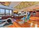 A large office, hardwood floors, ceiling fan, full gym set up with a desk near windows at 2870 Quartz Canyon Dr, Henderson, NV 89052