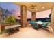 Charming outdoor patio with stone pillars, comfortable seating, and serene sunset views at 2870 Quartz Canyon Dr, Henderson, NV 89052