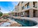 Beautiful backyard pool with stone accents, set against a backdrop of a luxury home with balcony at 2870 Quartz Canyon Dr, Henderson, NV 89052