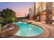 Beautiful pool area with rock waterfall feature, surrounded by lush landscaping and lounge chairs at 2870 Quartz Canyon Dr, Henderson, NV 89052