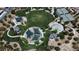 Aerial view of playground with tennis courts and open grass areas surrounded by trees and walkways at 5873 Skyfall Ct, Las Vegas, NV 89135