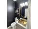 Elegant bathroom with gold vessel sink, modern fixtures, and dark walls at 5873 Skyfall Ct, Las Vegas, NV 89135
