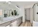 Modern bathroom featuring double sinks, gray cabinetry, and a glass-enclosed shower at 5873 Skyfall Ct, Las Vegas, NV 89135