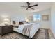 Bright bedroom with neutral decor, ceiling fan, a side table with lamp, and a patterned rug at 5873 Skyfall Ct, Las Vegas, NV 89135