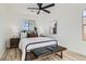 Comfortable bedroom with metal-framed bed, side tables with lamps, ceiling fan, and wood-look flooring at 5873 Skyfall Ct, Las Vegas, NV 89135
