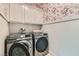 Well-equipped laundry room with overhead cabinets and modern Samsung washer and dryer set at 5873 Skyfall Ct, Las Vegas, NV 89135