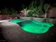 Beautiful in-ground pool featuring vibrant green lighting, a stone waterfall, and a tranquil setting at 5873 Skyfall Ct, Las Vegas, NV 89135