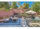 Relaxing patio furniture near a refreshing pool with a stone wall backdrop at 5873 Skyfall Ct, Las Vegas, NV 89135