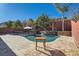 Luxury pool with a stone patio and a wooden table at 5873 Skyfall Ct, Las Vegas, NV 89135