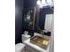 Stylish powder room with dark walls, a gold sink, and modern decor at 5873 Skyfall Ct, Las Vegas, NV 89135