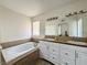 Bathroom features a soaking tub, dual sink vanity, and wood-look flooring at 6137 W Oakey Blvd # A, Las Vegas, NV 89146
