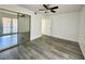 Bedroom with wood-look flooring, sliding closet doors, and a ceiling fan at 6137 W Oakey Blvd # A, Las Vegas, NV 89146