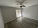 Bedroom features gray wood floors, ceiling fan and patio door at 6137 W Oakey Blvd # A, Las Vegas, NV 89146