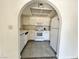 A bright galley kitchen featuring white appliances and a textured tile floor at 6137 W Oakey Blvd # A, Las Vegas, NV 89146