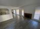 Open living room with brick fireplace, gray floors, and lots of natural light at 6137 W Oakey Blvd # A, Las Vegas, NV 89146