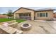 Backyard featuring artificial turf, stone firepit and patio area at 8351 Agave Bloom St, Las Vegas, NV 89131