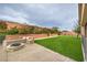 Landscaped backyard featuring artificial turf, firepit, and bench at 8351 Agave Bloom St, Las Vegas, NV 89131