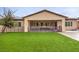 Wide view of the backyard featuring artificial turf and covered patio at 8351 Agave Bloom St, Las Vegas, NV 89131