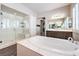 Elegant bathroom with large soaking tub, marble counters, and walk-in glass shower at 8351 Agave Bloom St, Las Vegas, NV 89131