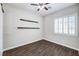 Neutral bedroom featuring wood-look flooring, floating shelves, and shuttered window at 8351 Agave Bloom St, Las Vegas, NV 89131