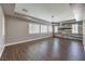 Spacious living room with a tray ceiling, wood-look flooring, and a decorative wood panel accent wall at 8351 Agave Bloom St, Las Vegas, NV 89131