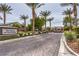 Entrance to The Estates at Tule Springs featuring palm trees, greenery, and well-maintained landscaping at 8351 Agave Bloom St, Las Vegas, NV 89131