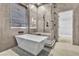 Modern bathroom with soaking tub, walk-in shower, and neutral tile at 120 Emerald Dunes Cir, Henderson, NV 89052