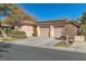 Tan house with solar panels, two-car garage, and neatly landscaped yard at 120 Emerald Dunes Cir, Henderson, NV 89052