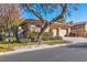 Two-story house with solar panels, two-car garage, mature tree, and lush landscaping at 120 Emerald Dunes Cir, Henderson, NV 89052