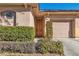 Home's front entrance with wood door and neatly trimmed shrubs at 120 Emerald Dunes Cir, Henderson, NV 89052